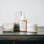 Elegant flat lay of natural skincare products, featuring a vitamin C serum and face balm.