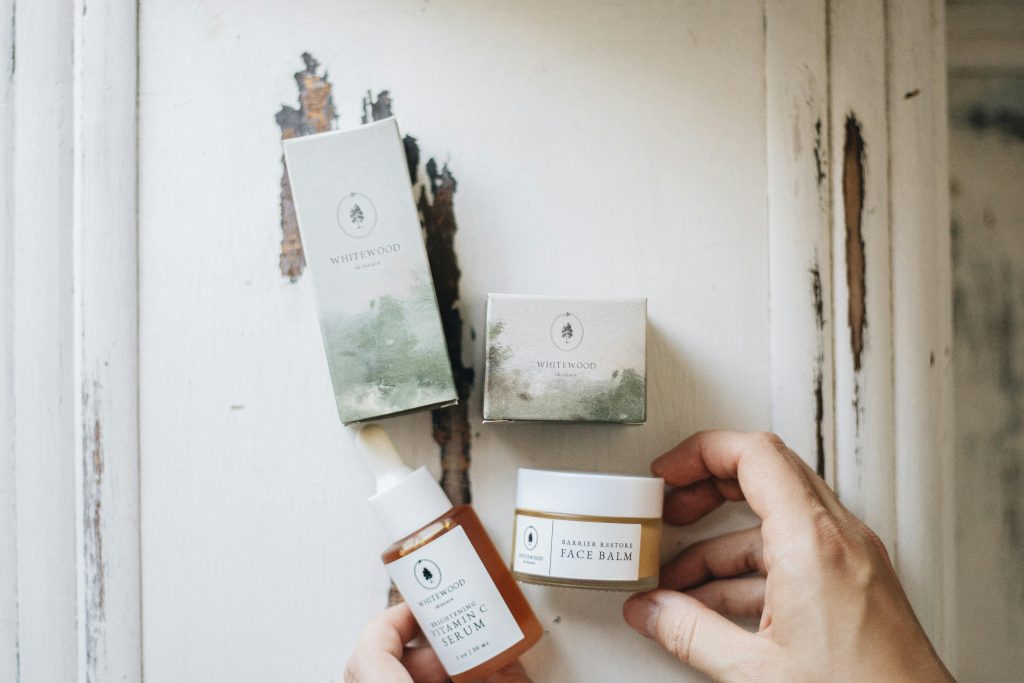 High-angle view of natural skincare products featuring face serum and balm with eco-friendly packaging.